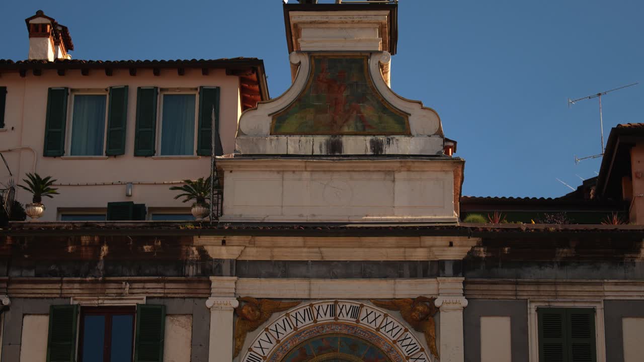 Torre dell'orologio rinascimentale a Brescia con quadrante astronomico e figure campanarie, cielo blu. Torre dell’Orologio.