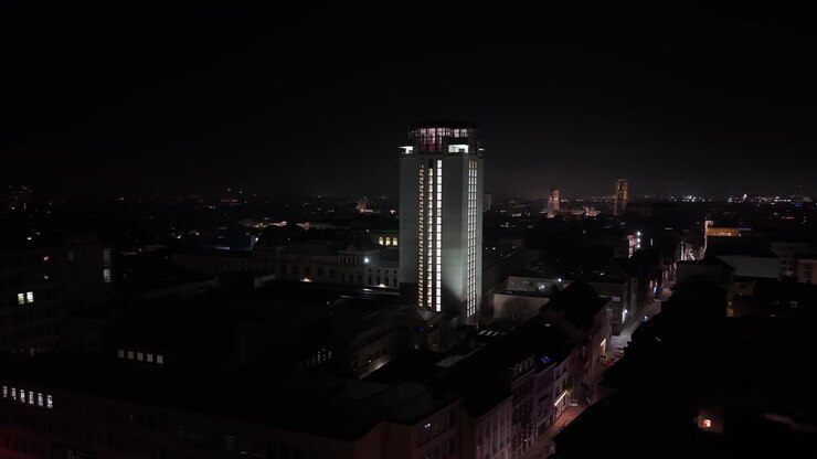 Paesaggio notturno di Gand che evidenzia la Torre del Libro illuminata, mostrando architettura storica e lo skyline suggestivo della città di notte.