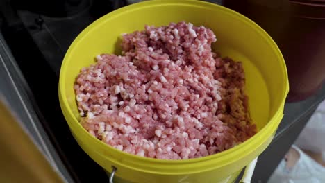 full bucket of minced fresh pork meat, close up motion back view