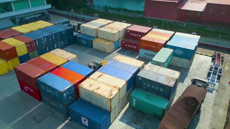 vista in orbita del drone del magazzino della fabbrica di semi di olio di palma con container di carico e carrelli elevatori, in malesia