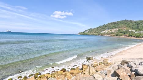 a serene coastal panorama with clear skies and gentle waves at kalim beach, captured in bright daylight with a steady camera