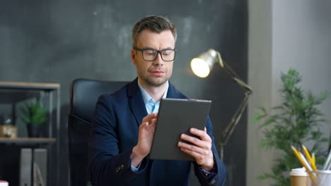 hombre de negocios con gafas usando tableta en la oficina 1