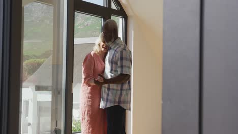 happy senior diverse couple dancing in living room at retirement home