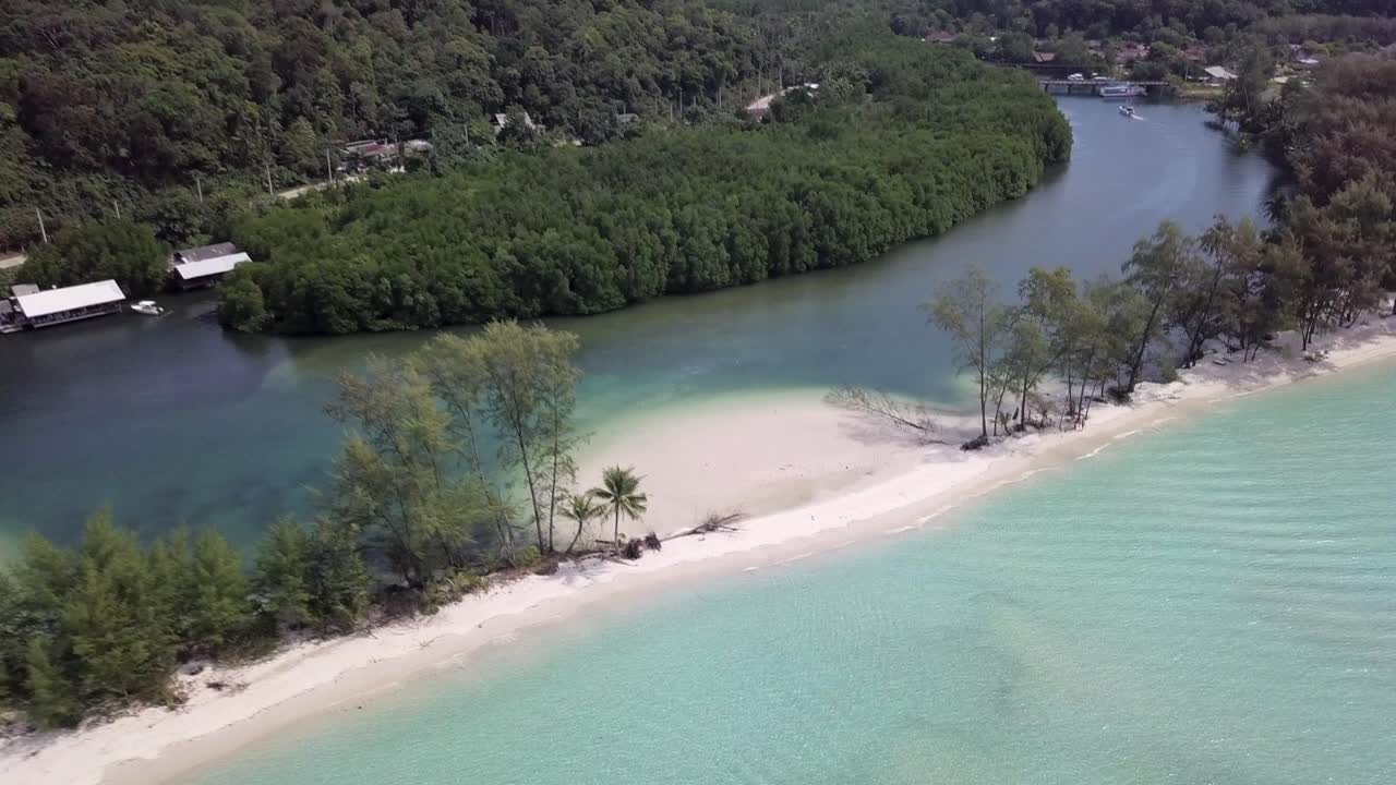 Aerial view of Klong Chao Beach,backwards slowly,one side river one side sea divided by white sand beach surrounded by lush greenery.