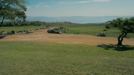 carro lento sobre hierba verde y camino de tierra, gran lago en la distancia