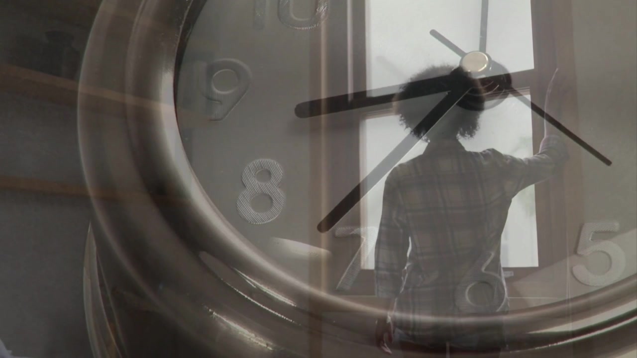 Clock overlay moving, woman turning to back and resting hand on window, showing business time