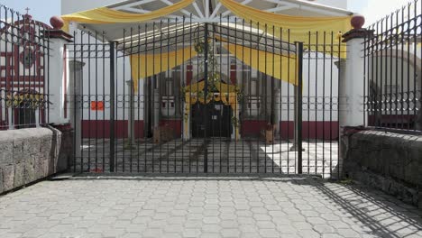 church entrance secured by metal railings with wooden seating