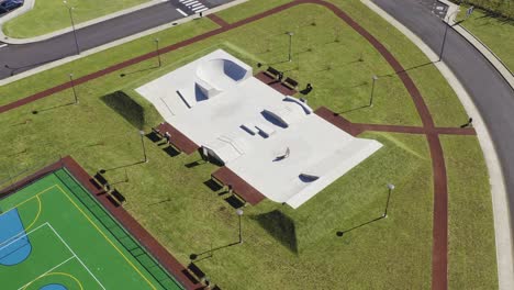 drone-footage-of-concrete-skate-park-surrounded-by-green-grass-Velas,-Sao-Jorge-island,-Azores,-Portugal