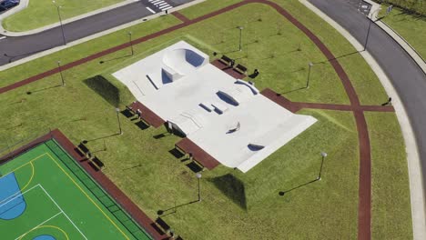 drone footage of concrete skate park surrounded by green grass velas, sao jorge island, azores, portugal