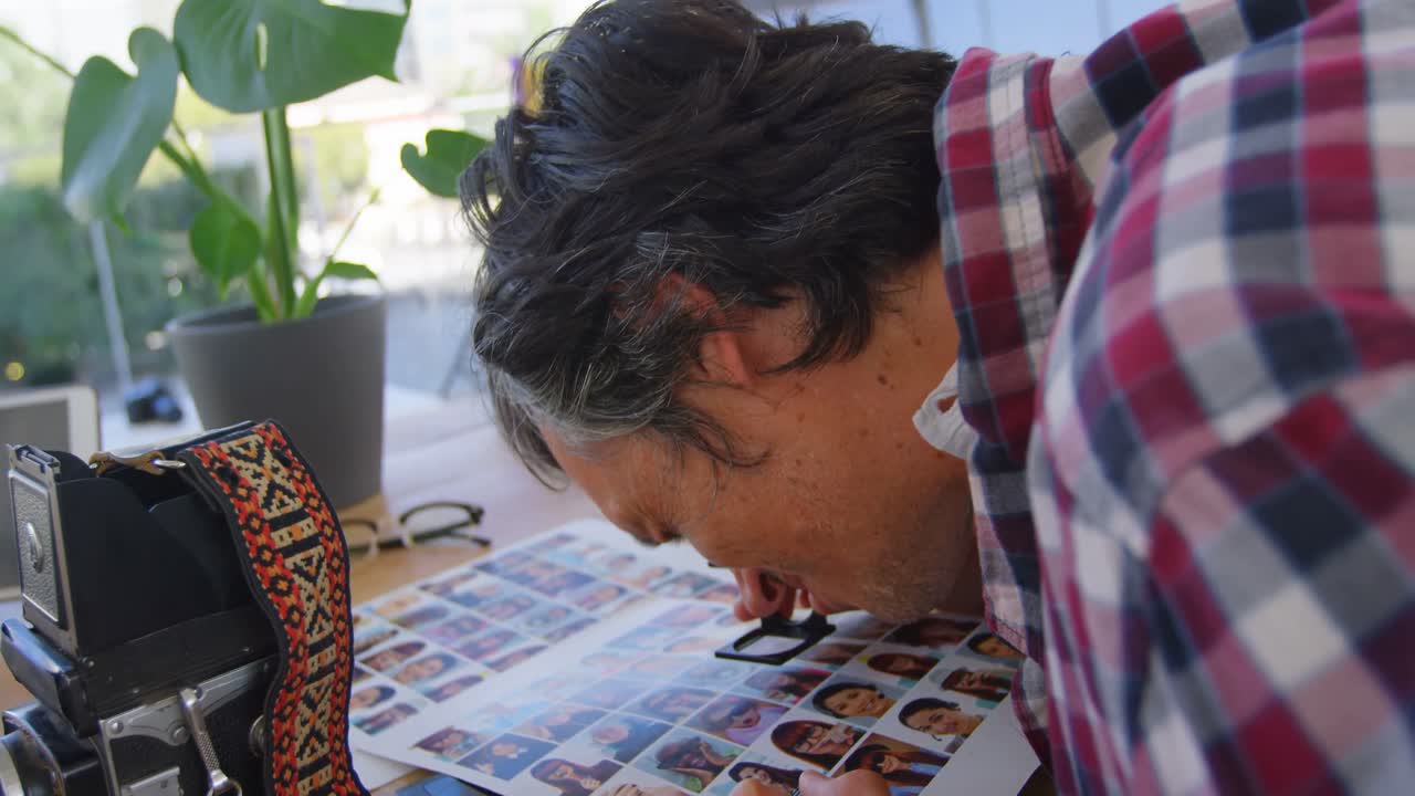 fotógrafo masculino comprobando fotos con lupa 4k