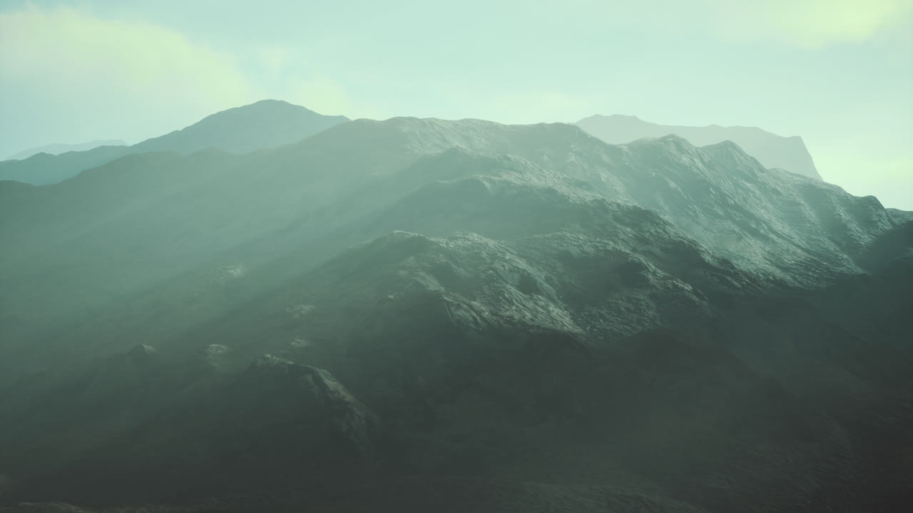 Mountain ranges shrouded in mist during early morning light