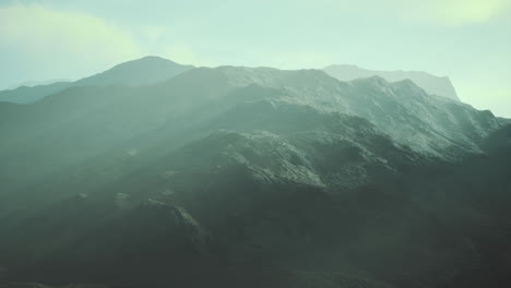 Mountain ranges shrouded in mist during early morning light