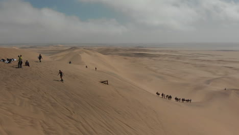 Girl-using-sand-board-down-slope-for-the-first-time