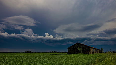 Old-ghost-town-house-or-barn-with-a-stormy-cloudscape-time-lapse-overhead