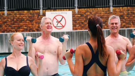 Entrenador-De-Natación-Que-Ayuda-A-Personas-Mayores-A-Realizar-Ejercicio.