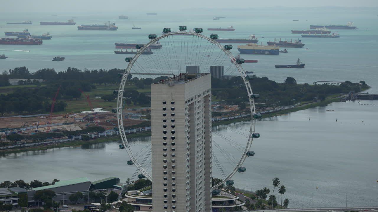 container ships and ferris wheel in singapore