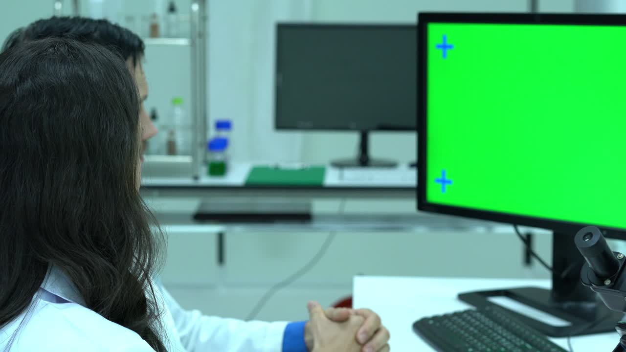científico masculino hablando de trabajar en un laboratorio moderno o centro médico. monitor de fondo pantalla verde. concepto de ciencia, desarrollo de pruebas y industria de laboratorio.
