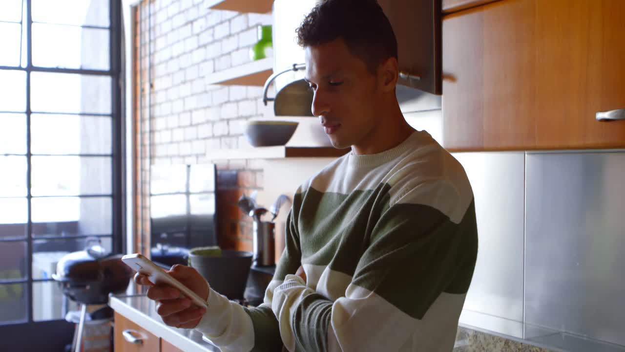 hombre usando teléfono móvil en la cocina 4k