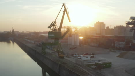 Frankfurt-Am-Main-Puerto-De-Osthafen-Con-Grúa-De-Carga-En-La-Neblina-De-La-Luz-Del-Sol-Temprano-En-La-Mañana,-Antena-Lateral-Izquierda