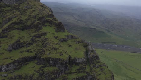 Gran-Acantilado-De-Roca-De-Musgo-Verde-Con-Clima-Lluvioso-En-Islandia,-Antena