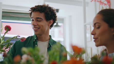 african guy smell flower composition in store. joyful man choose hold bouquet.
