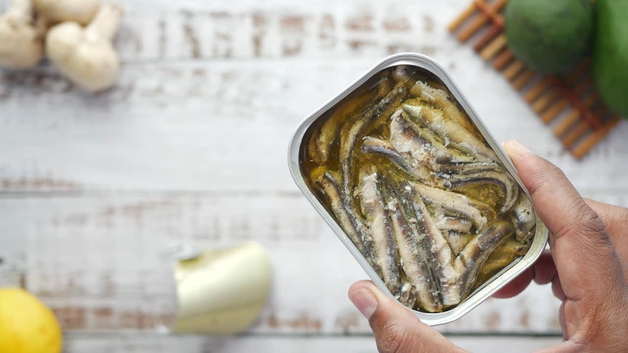 anchoas enlatadas en la mano