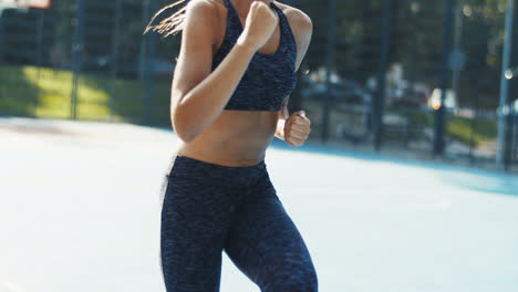 Mujer-Deportiva-Corriendo-En-Su-Lugar-En-La-Cancha-Al-Aire-Libre-En-Un-Día-De-Verano