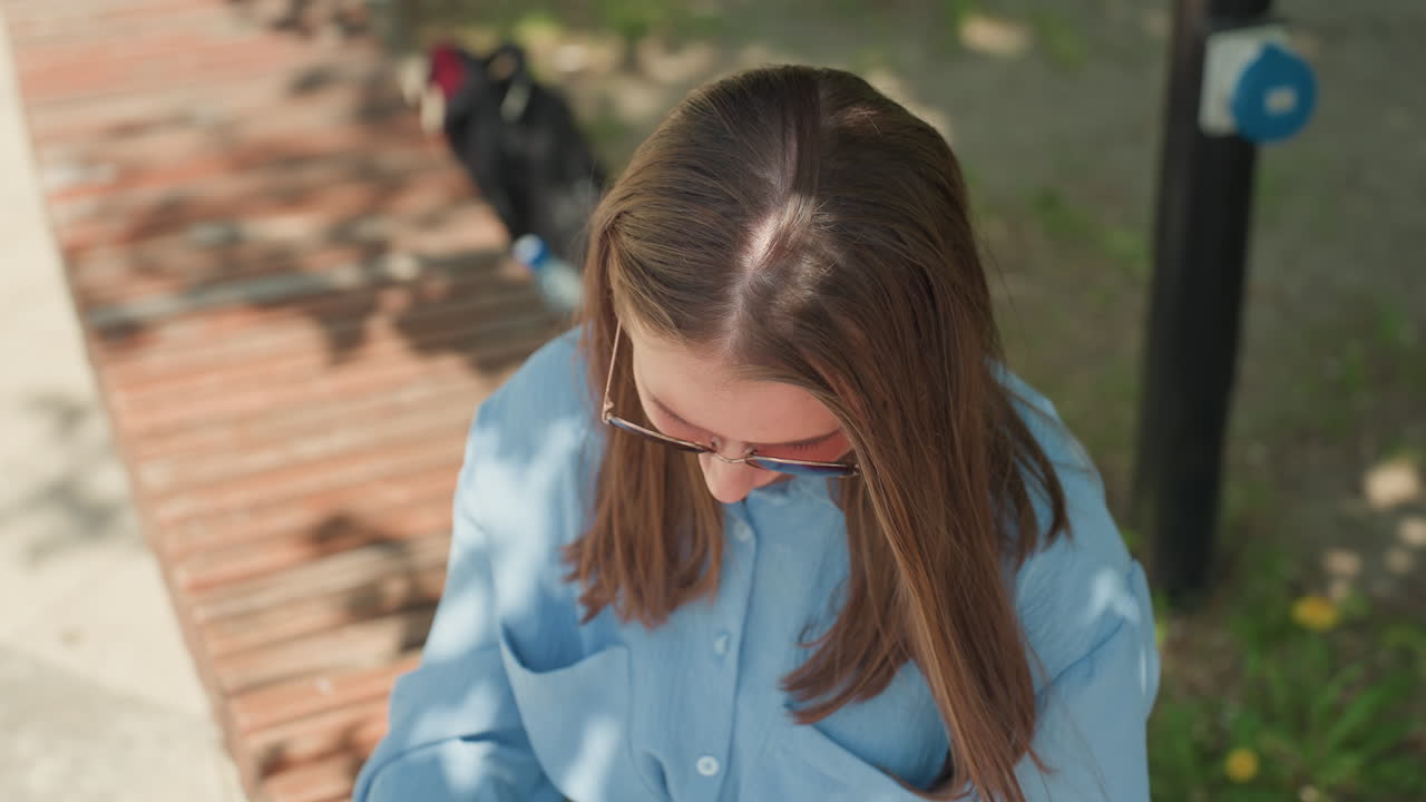 선글라스를 고쳐 쓰는 여성, 장난기 넘치는 미소와 여름 분위기, 데님을 입고 쾌활한 표정을 짓는 여성의 클로즈업, 화창한 날씨에 공원을 배경으로 선글라스를 고쳐 쓰는 여성의 인플루언서 스타일 촬영