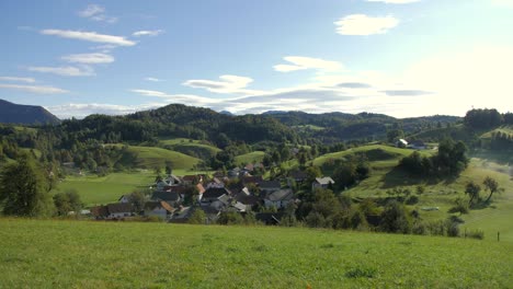 wide left pan of picturesque village ponikve in slovenia, rolling hills morning