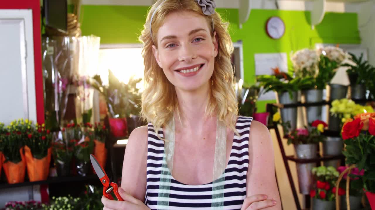 retrato de una florista de pie con los brazos cruzados en una floristería