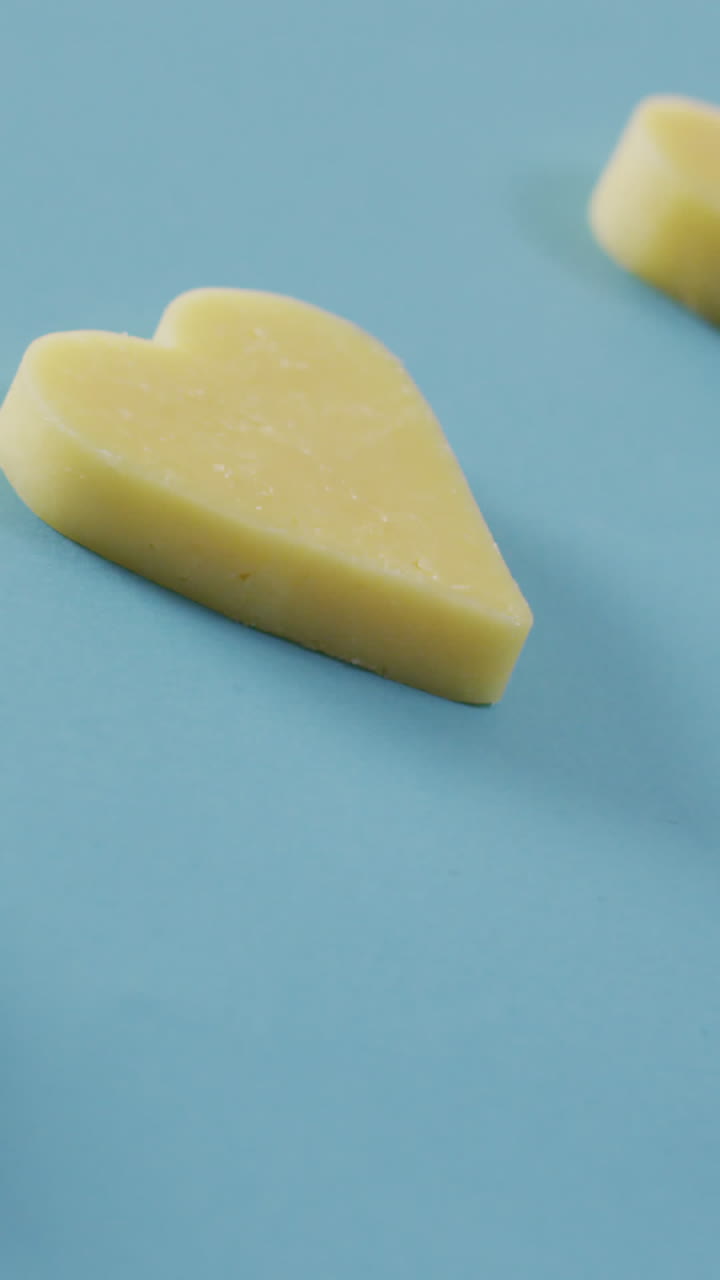 video de una fila de formas de corazón de queso sobre fondo azul con espacio para copiar
