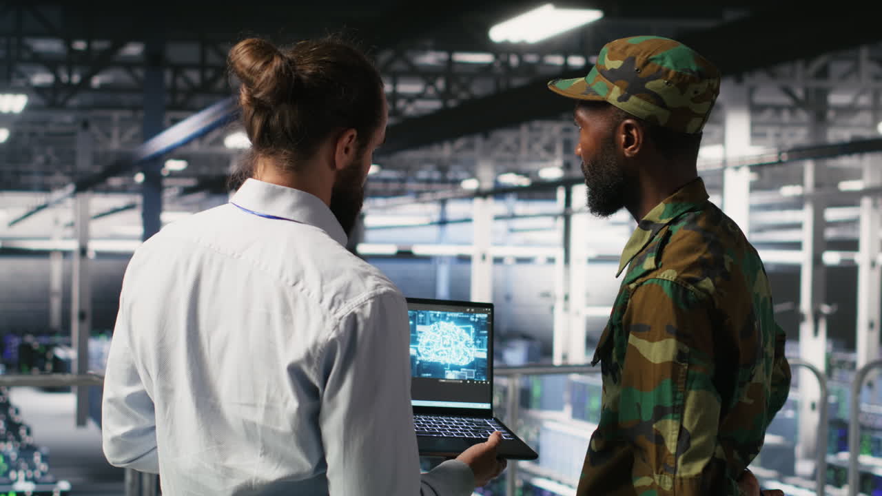 Military technicians in secure data center use laptop to monitor AI systems