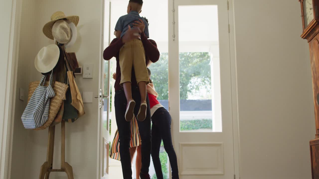 Happy african american family entering the house from front door