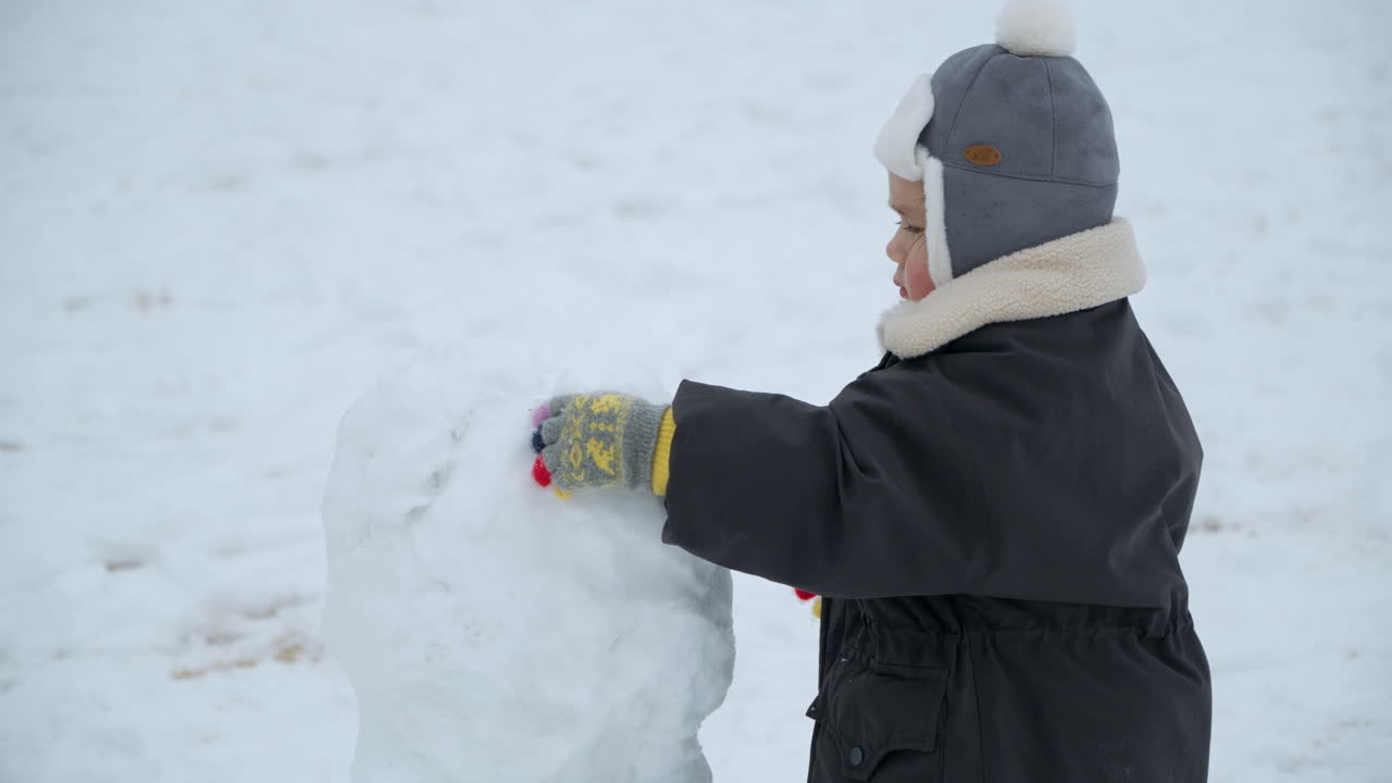 한국 평창군에 있는 대규모 양농장에서 겨울날 눈과 놀고 있는 귀여운 어린 소녀