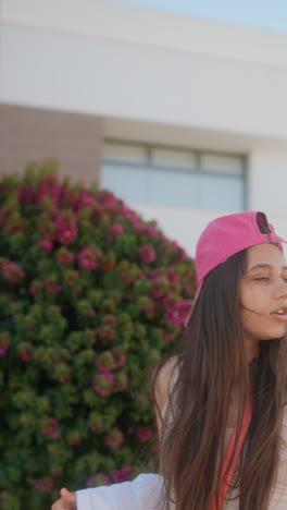 young woman wearing a pink hat in a city park