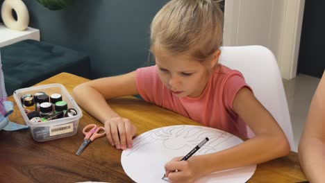 girl drawing a spider on paper