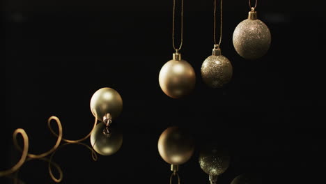 video of gold christmas baubles decorations with copy space on black background