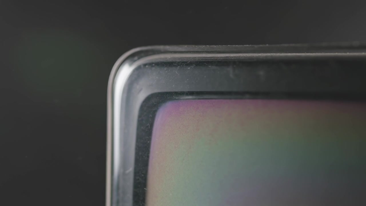 Shifting camera revealing rounded corner in studio to inspect showing bezel rainbow dust scratches