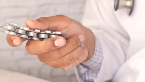 doctor holding blister packs of pills