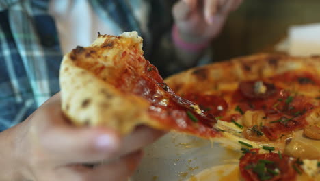 persona comiendo una rebanada de pizza