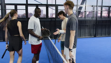 diverse friends enjoying padel tennis match, laughing and celebrating together, on indoor court