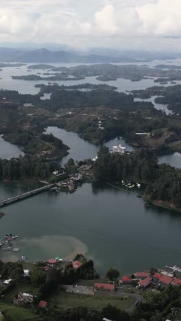 Guatape-mountains-and-landscapes,-waters-of-the-Guatape-reservoir,-vertical-mode