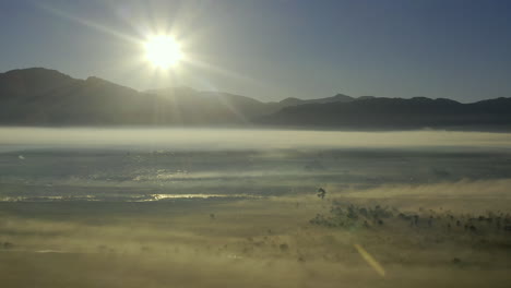 mist across a field in the countryside at sunset