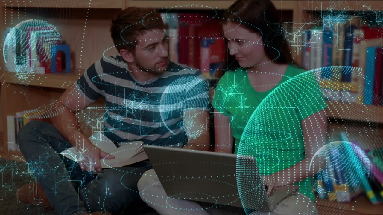 Right student typing on laptop, left student pointing book, leaning in, holo rings aiding studying