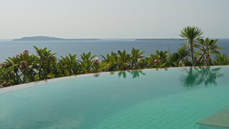 slow calming pan over the infinity pool with views across the gilli islands in indonesia