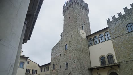 Toma-De-ángulo-Bajo-De-La-Torre-Del-Reloj-Del-Palacio-Dei-Priori-En-La-Plaza-De-Arezzo-En-Toscana,-Italia