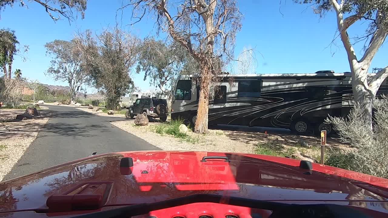 conduzca a través del campamento de boulder beach en el área recreativa nacional del lago hidromiel, mientras viaja en un vehículo rojo