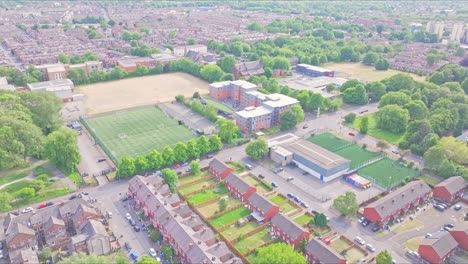 aerial footage of dilworth street, manchester, showing red-brick terraced homes, university sports fields, tree-lined roads, and the urban sprawl in the university and ardwick district surroundings