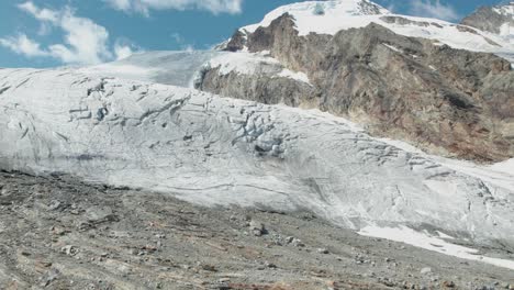 end lip of ice glacier in switzerland getting smaller due to global warming, aerial view of glacier high up in the mountains