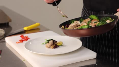 chef preparing a chicken and vegetable pasta dish